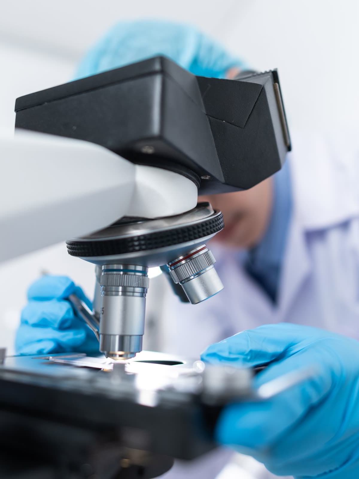 Scientist using a microscope in a medical research laboratory