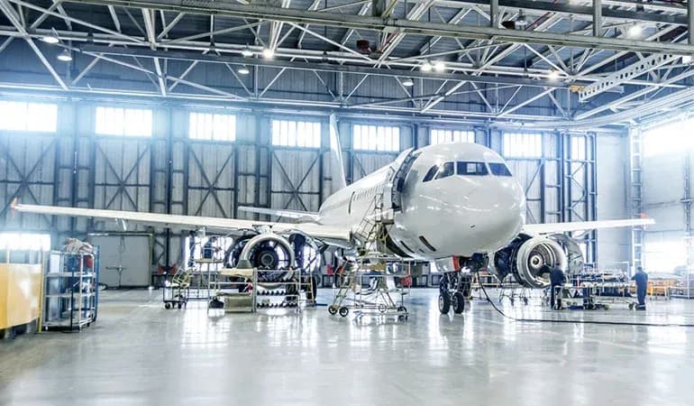 Commercial aircraft undergoing maintenance in a hangar